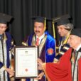 Picture Dr Azad Moopen Founder Chairman and MD Aster DM Healthcare receiving the Doctorate for Philanthropy certificate for his commitment to serving m